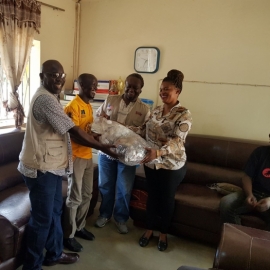  Handing over the glasses. L-R Alex, Dr. Opio, Aswani, Faith