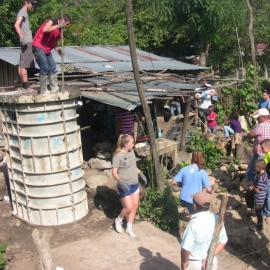 Ouvriers compactant le ciment dans le moule à latrine 